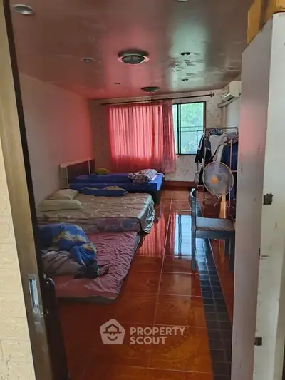 Cozy bedroom with multiple beds and natural light from window