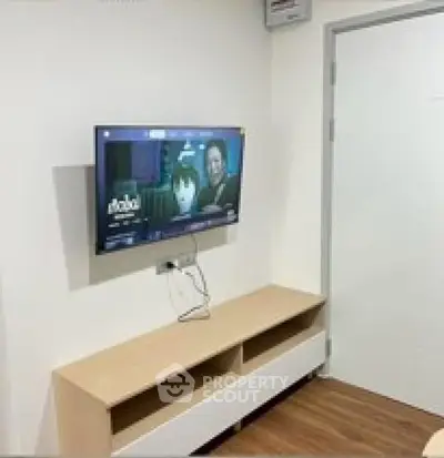 Modern living room with wall-mounted TV and sleek wooden cabinet