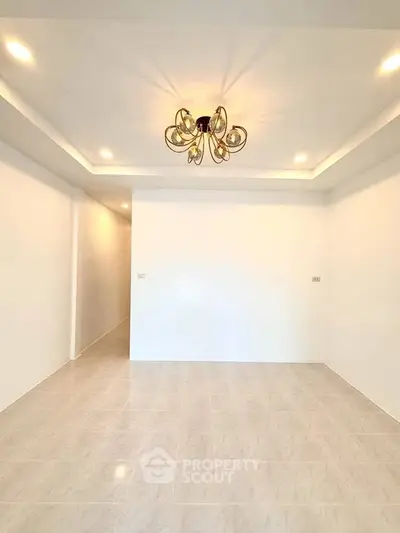 Spacious modern living room with elegant lighting and sleek tile flooring.