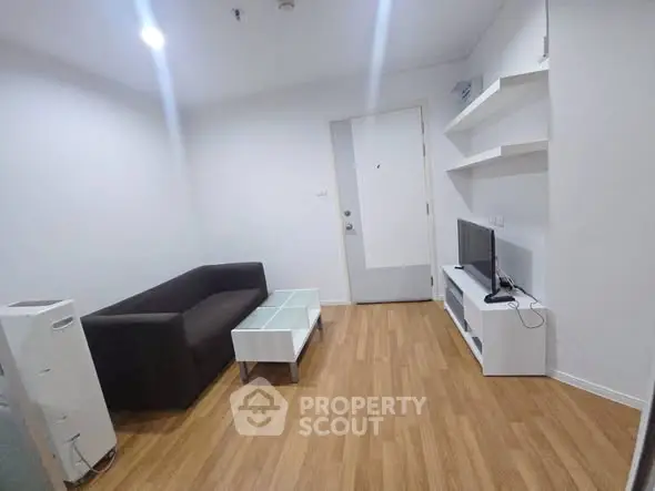 Modern living room with sleek furniture and wooden flooring in a stylish apartment.