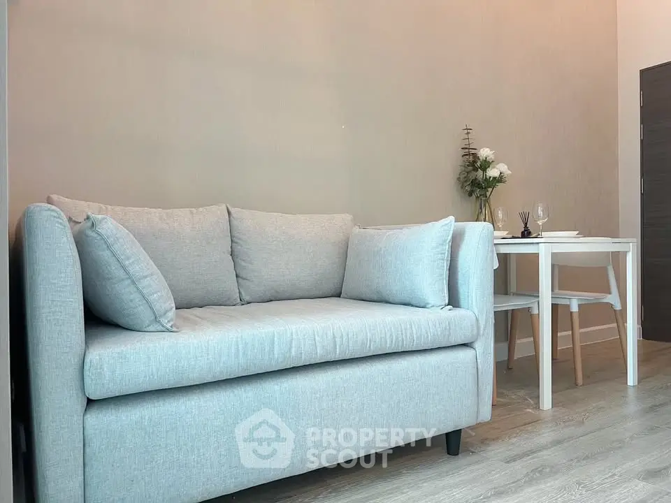 Cozy living room with modern gray sofa and elegant dining table, perfect for urban living.