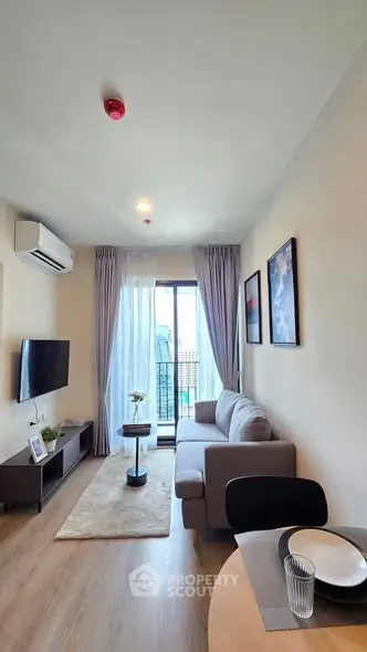 Modern living room with balcony, stylish decor, and natural light