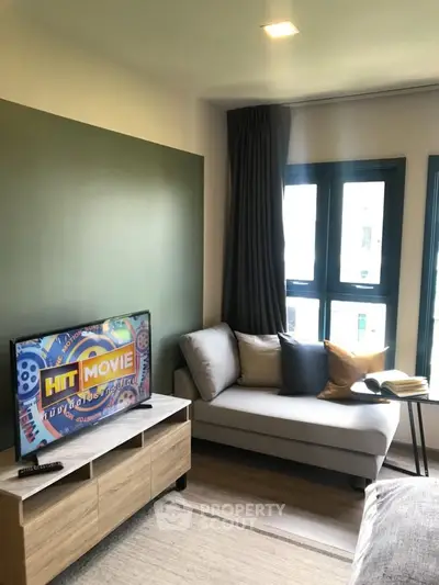 Modern living room with stylish decor and natural light, featuring a cozy sofa and entertainment setup.