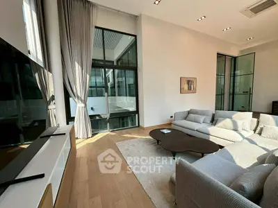 Spacious modern living room with large windows and elegant furnishings
