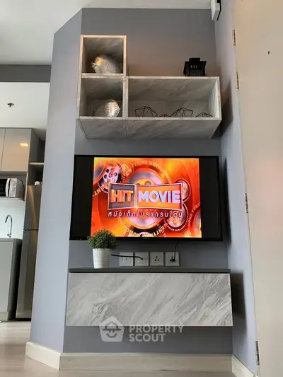 Modern living room with sleek TV setup and stylish shelving in a contemporary apartment.