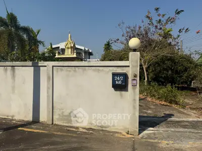 Charming property entrance with traditional shrine and lush greenery