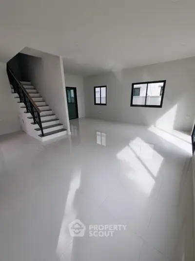 Spacious modern living room with sleek staircase and large windows