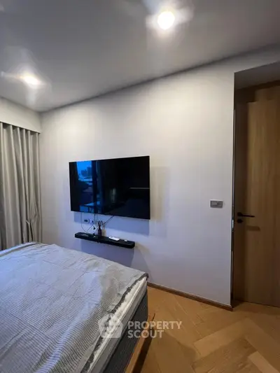 Modern bedroom with wall-mounted TV and elegant lighting