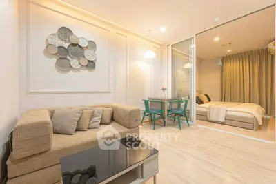 Modern open-plan living room with cozy sofa and stylish decor leading to a chic bedroom.