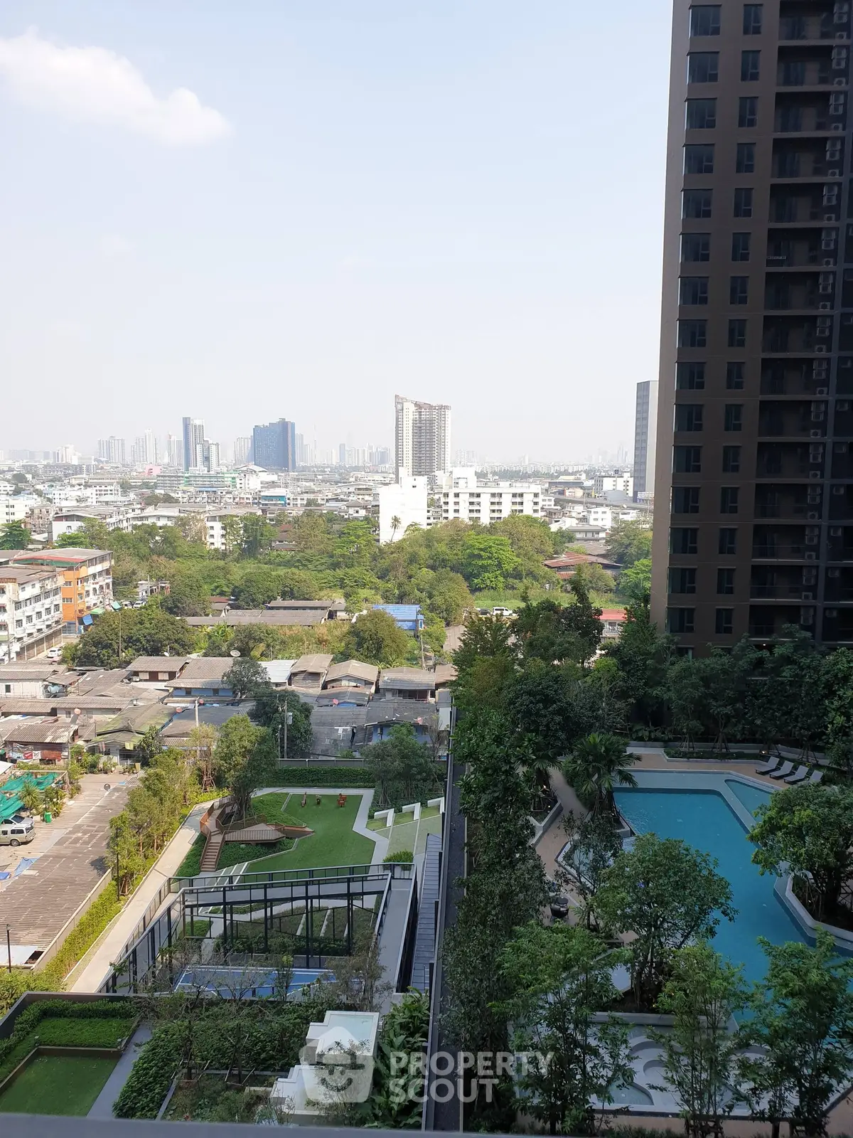 Stunning cityscape view from high-rise apartment with pool and lush greenery