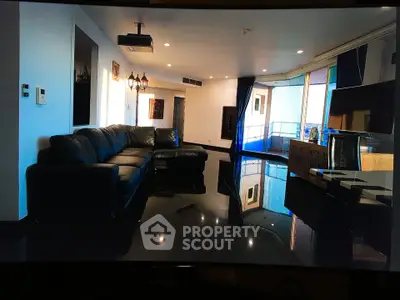 Spacious living room with sleek black leather sofa and glossy floors, featuring a large balcony with city views.