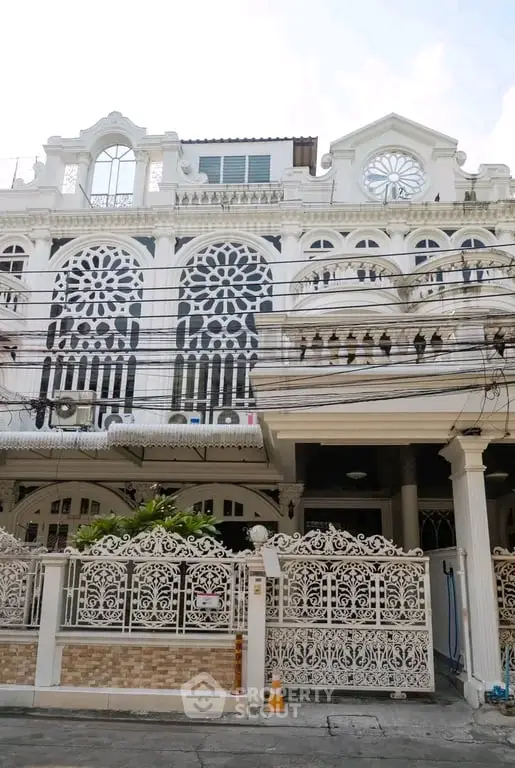 Stunning white facade of a multi-story building with intricate ironwork and classic architectural details.