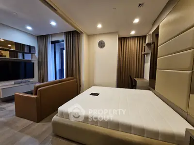 Modern bedroom with sleek design, featuring a large bed, stylish sofa, and wall-mounted TV for ultimate comfort.