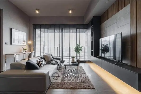 Modern living room with sleek design, large TV, and cozy seating area.