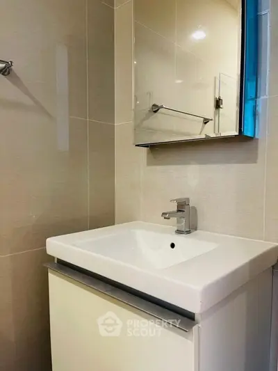 Modern bathroom with sleek sink and mirror in contemporary design.