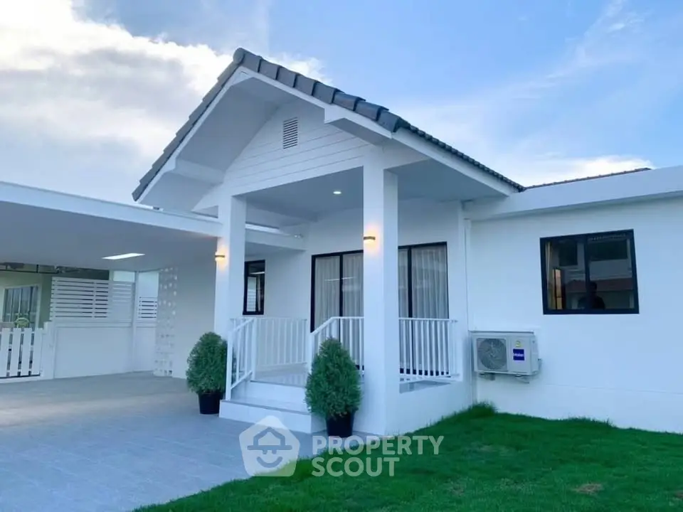 Charming white house with modern design and lush green lawn