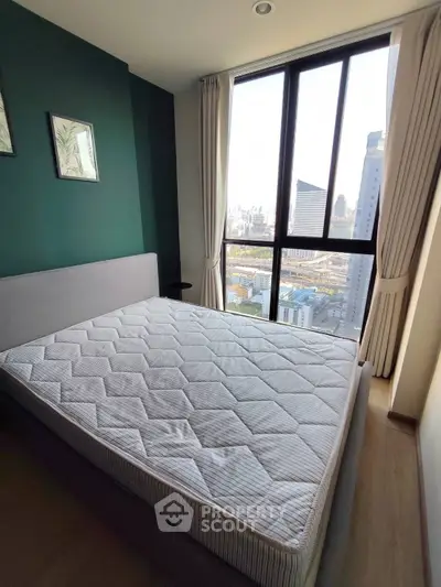 Modern bedroom with large window offering stunning city view, featuring a comfortable bed and elegant decor.