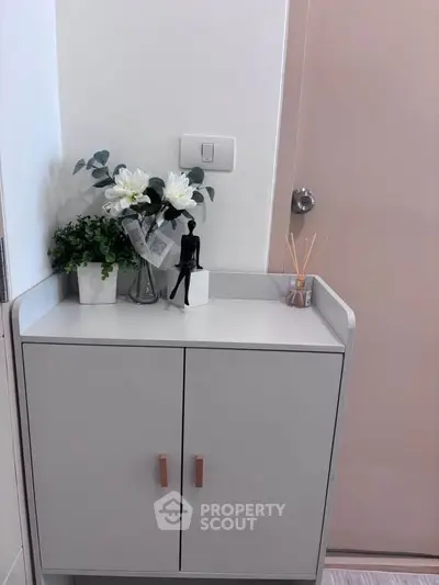 Stylish entryway cabinet with decorative plants and modern accents in a cozy home setting.