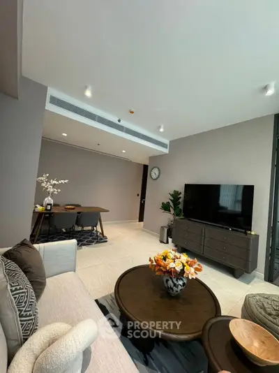 Modern living room with stylish furniture and open dining area, perfect for entertaining guests.