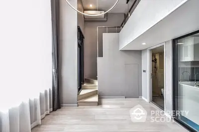 Modern duplex apartment interior with open-plan kitchen, sleek finishes, and a staircase leading to an upper level, embodying contemporary urban living.