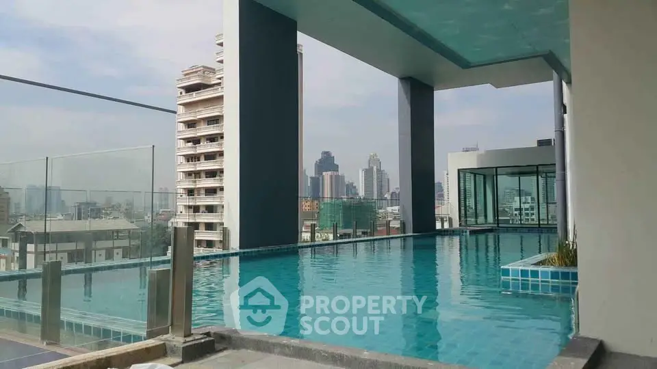 Luxurious rooftop pool with stunning city skyline views in modern high-rise building.