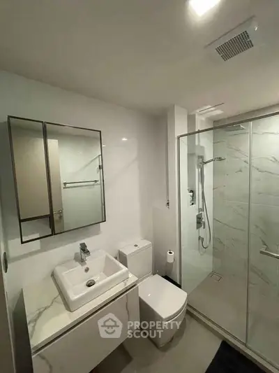 Modern bathroom with sleek design, featuring a glass shower and stylish vanity.
