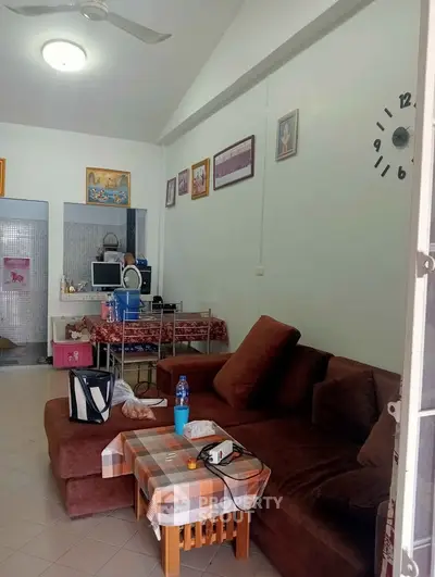 Cozy living room with brown sofa and wall decor, perfect for relaxation.