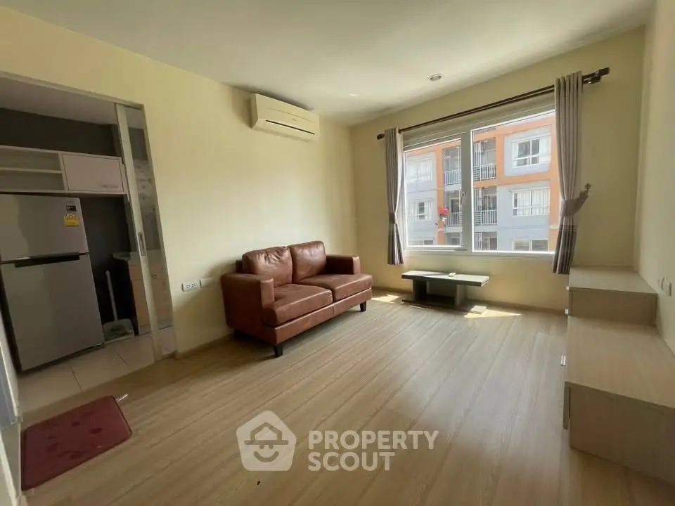 Spacious living room with natural light and modern furnishings in a stylish apartment.