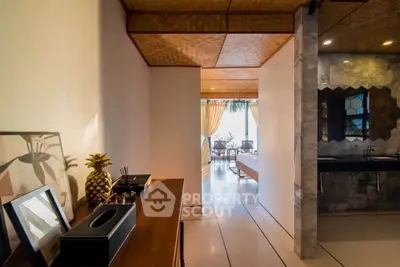 Stylish modern interior with open layout and unique ceiling design, featuring a glimpse of a cozy living area.