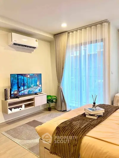Modern bedroom with cozy decor, featuring a wall-mounted TV and air conditioning.