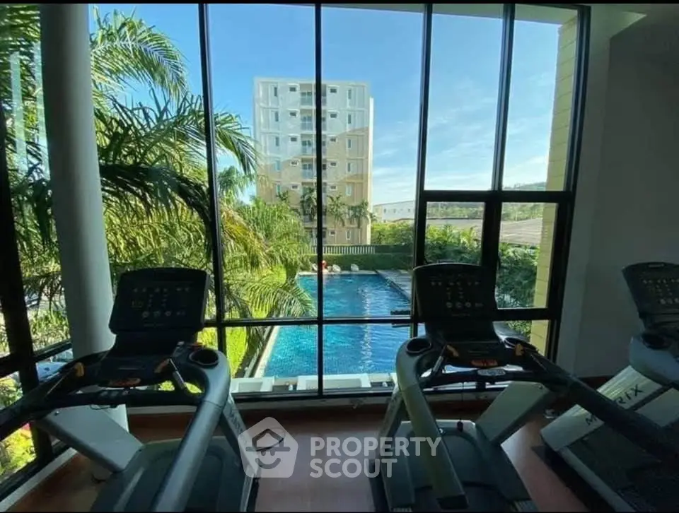Modern gym with pool view in luxury apartment complex