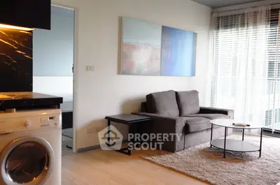 Modern living room with stylish decor and natural light, featuring a cozy sofa and contemporary artwork.