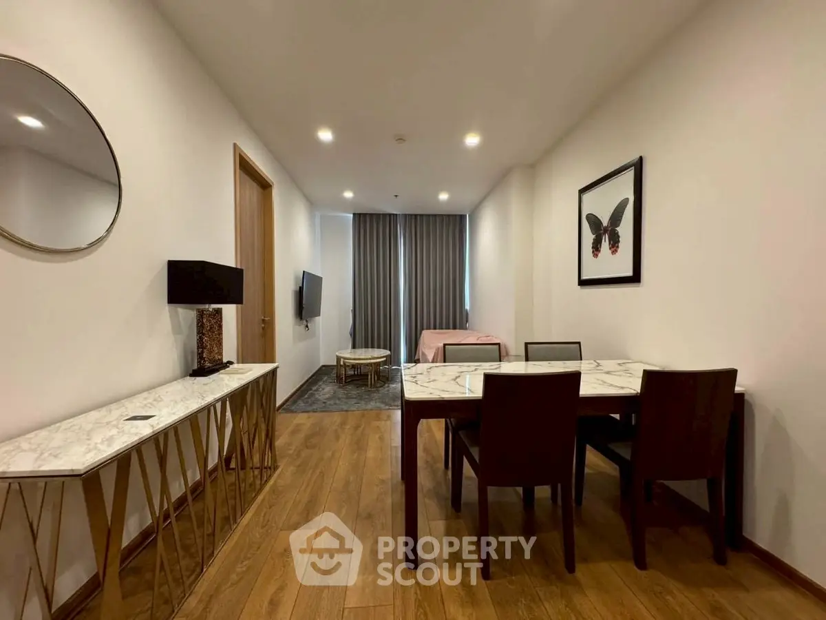 Modern dining area with elegant decor and wooden flooring in a stylish apartment.