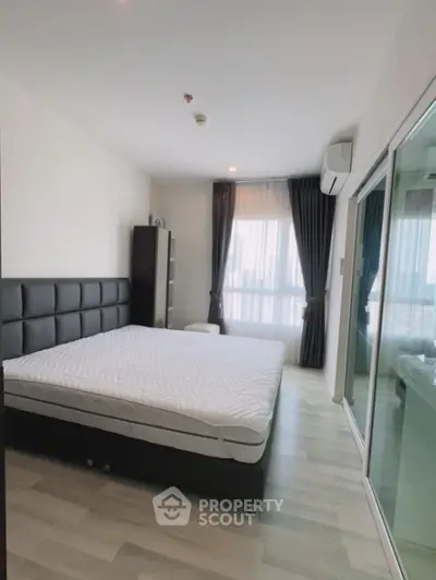 Spacious bedroom with large windows, modern design, ample natural light, and sleek furnishings, perfect for urban living.
