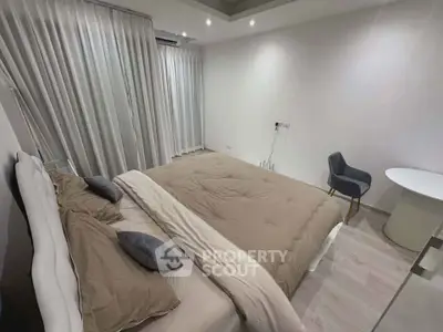 Modern bedroom with cozy bedding and elegant decor in a stylish apartment.