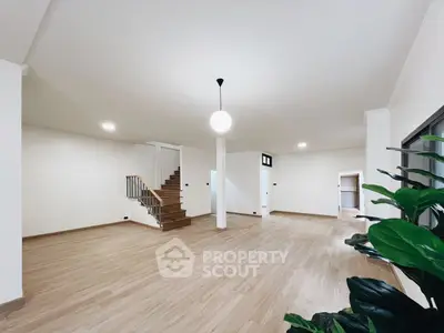 Spacious open-plan living area with modern staircase and wooden flooring