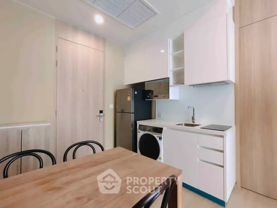 Modern kitchen with integrated appliances and wooden dining table