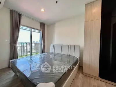 Modern bedroom with large window and city view, featuring a sleek bed and stylish wardrobe.