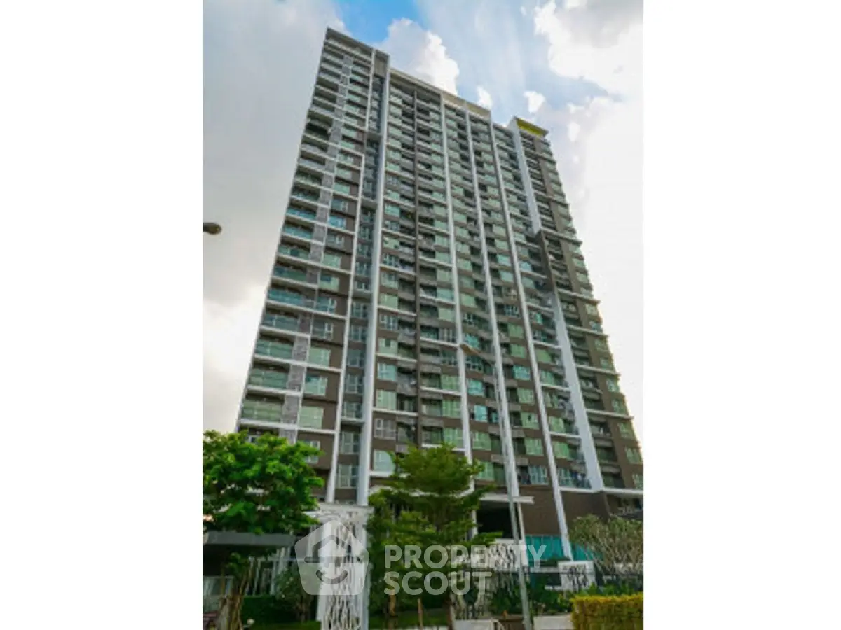 Modern high-rise condominium with lush landscaping and contemporary design.