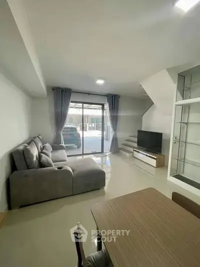 Modern living room with sleek furniture and large windows offering ample natural light.