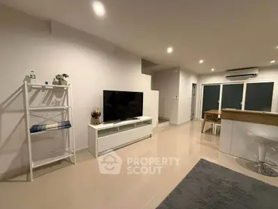 Modern living room with sleek TV setup and open kitchen layout