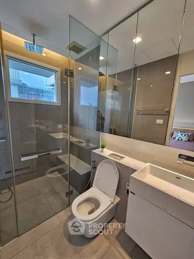 Modern bathroom with glass shower and sleek fixtures in a contemporary apartment.