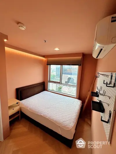 Cozy bedroom with city view, featuring modern decor and air conditioning.