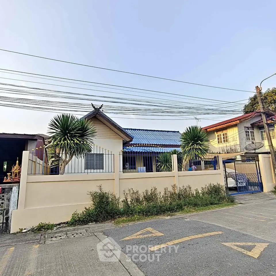 Charming suburban house with a fenced yard and lush greenery, perfect for family living.