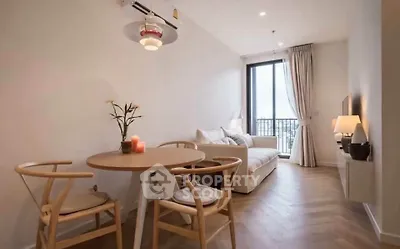 Modern living room with elegant decor and large window offering natural light and city view.