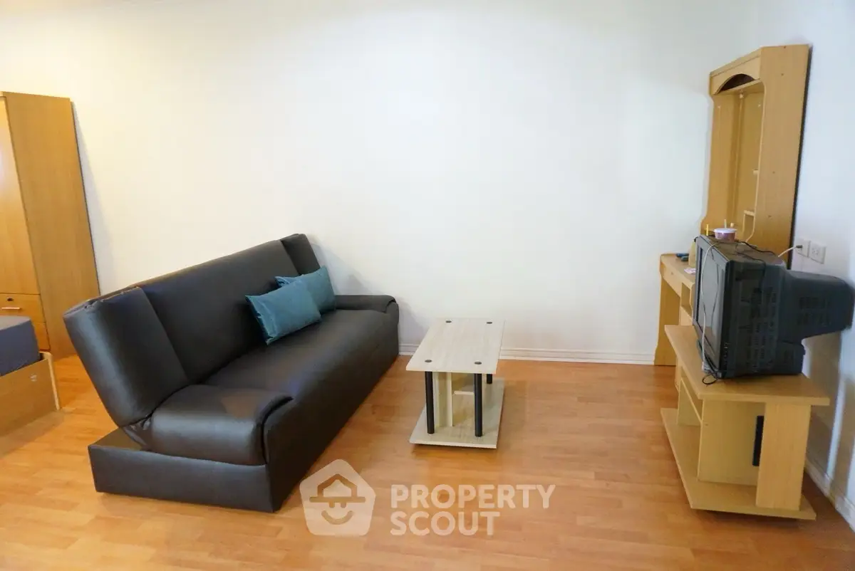 Cozy living room with modern black sofa and wooden TV stand