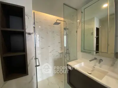 Modern bathroom with glass shower and sleek fixtures in luxury apartment