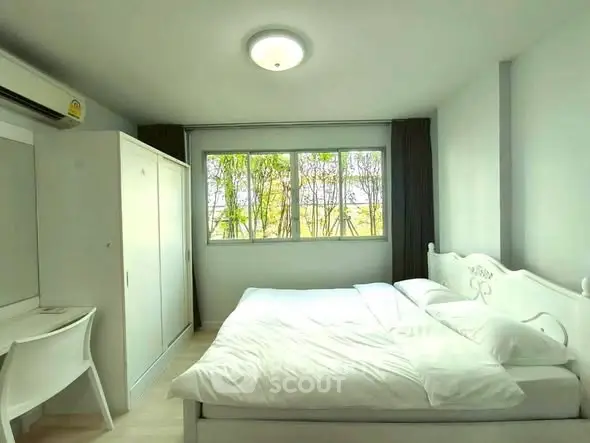 Bright and cozy bedroom with large window and modern furnishings