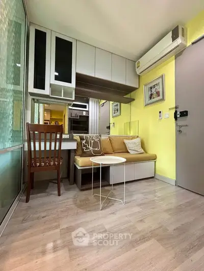 Cozy living room with modern decor and air conditioning in a compact apartment.