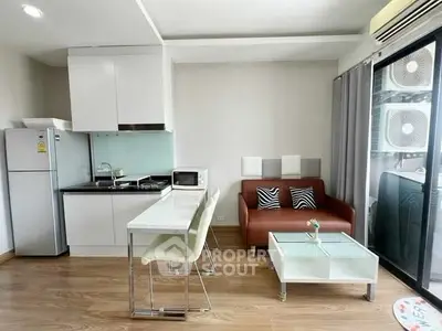Modern open-layout kitchen and living area with sleek furniture and natural light.
